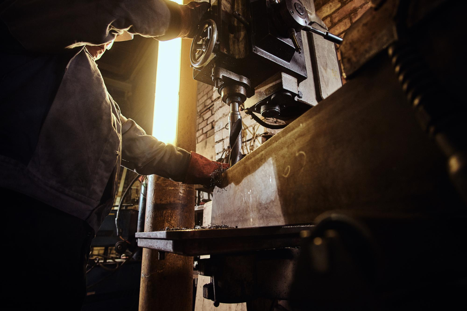 man-is-working-with-giant-drill-busy-metal-factory