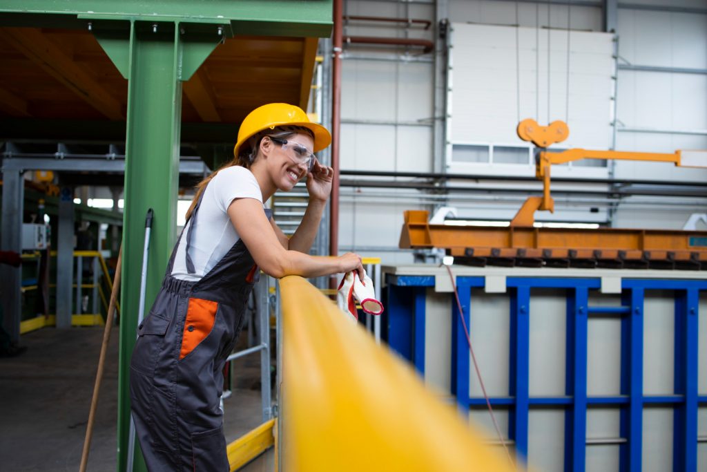 portrait-female-factory-worker-leaning-metal-railings-industrial-production-hall